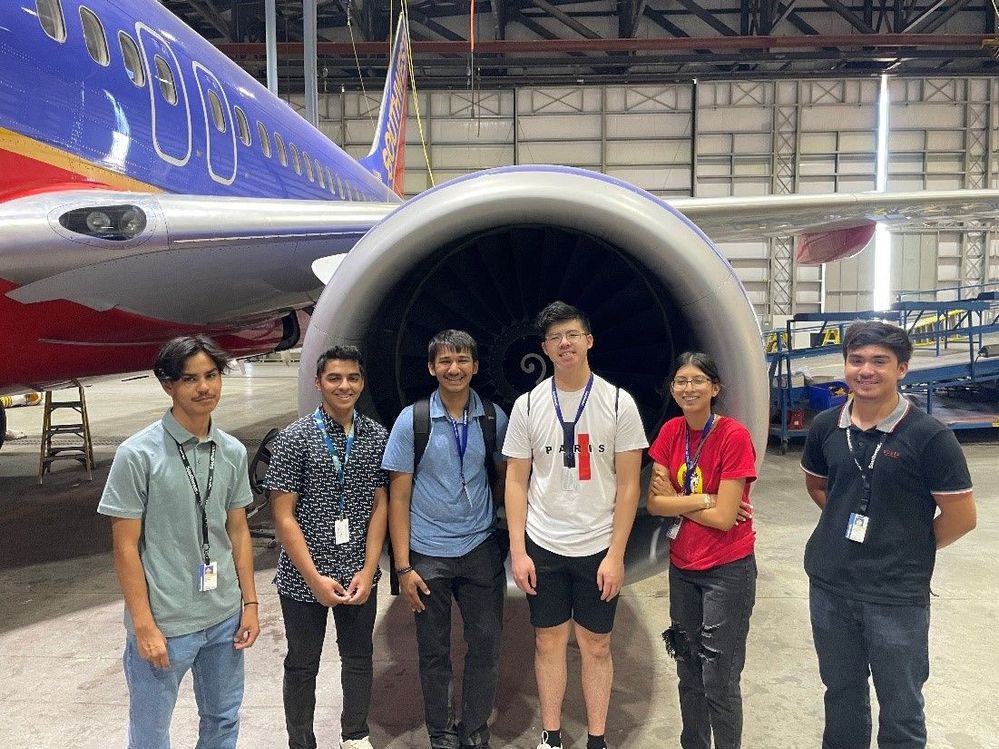 Students in front of an aircraft engine.jpg