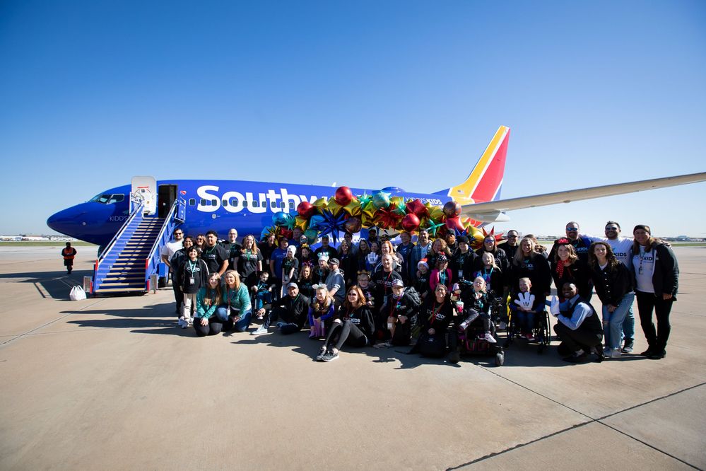 The 2022 Kidd’s Kids Trip families pose in front of the Southwest Airlines charter aircraft prior to departure.
