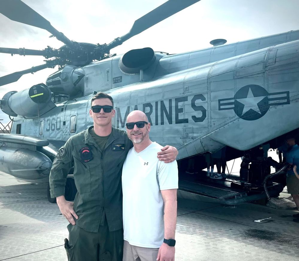 Alec and his father, Steve, in front of a Marine helicopter